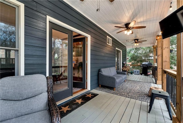 deck with a grill and ceiling fan