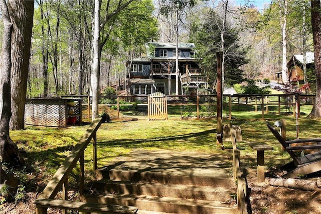 view of yard featuring fence and stairs