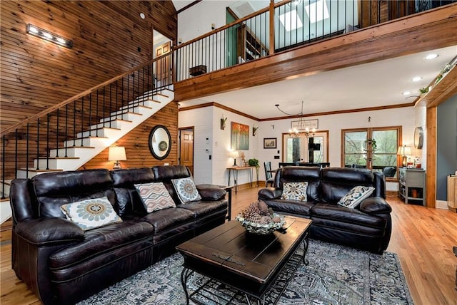 living room featuring ornamental molding, wood finished floors, a high ceiling, stairs, and baseboards