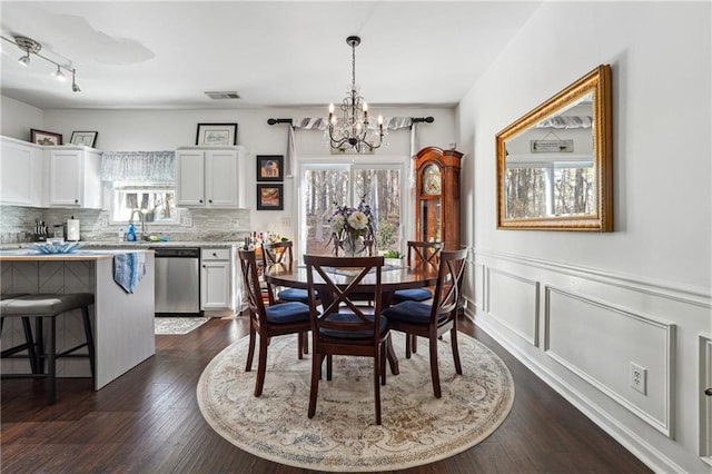 dining space with an inviting chandelier and dark hardwood / wood-style flooring