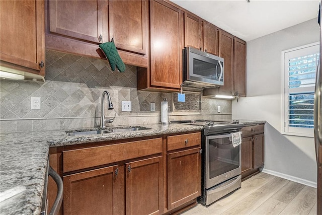 115 Winding River Dr Unit B, Atlanta, GA 30350 - kitchen featuring stainless steel appliances, light wood-style flooring, light stone counters, and tasteful backsplash