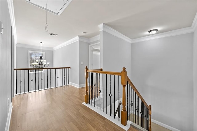 120 Daniel Creek Ln, Sugar Hill, GA 30518 - hallway featuring attic access, an upstairs landing, wood finished floors, crown molding, and a chandelier