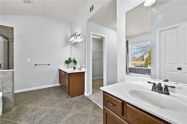 120 Daniel Creek Ln, Sugar Hill, GA 30518 - bathroom with vaulted ceiling, a stall shower, two vanities, and a spacious closet