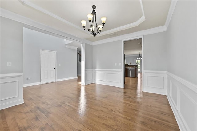 120 Daniel Creek Ln, Sugar Hill, GA 30518 - unfurnished dining area with a chandelier, a raised ceiling, ornamental molding, wood finished floors, and wainscoting