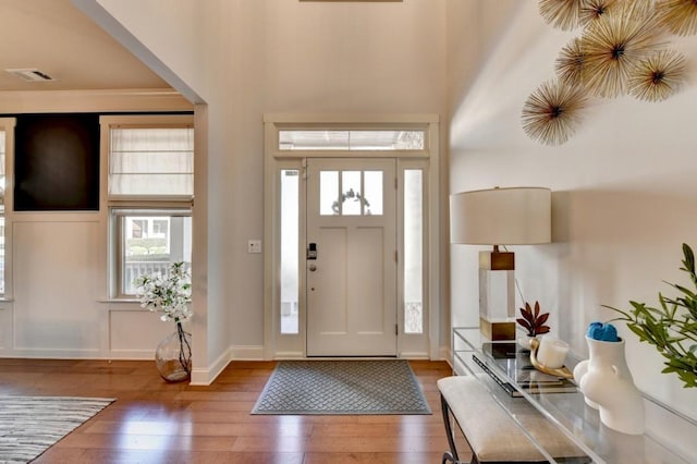 foyer entrance with dark wood-type flooring and a high ceiling