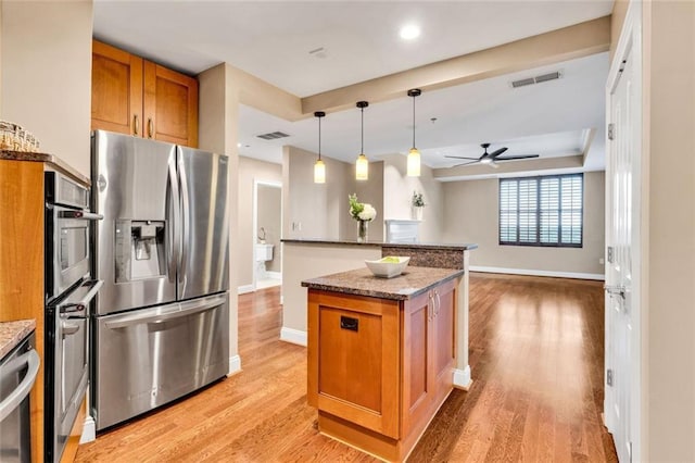2881 Peachtree Rd NE Unit 1202, Atlanta, GA 30305 - kitchen with stainless steel appliances, brown cabinetry, ceiling fan, light wood-type flooring, and baseboards