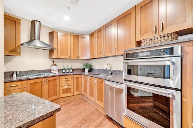 2881 Peachtree Rd NE Unit 1202, Atlanta, GA 30305 - kitchen with wall chimney range hood, stainless steel appliances, a sink, light wood finished floors, and dark stone counters