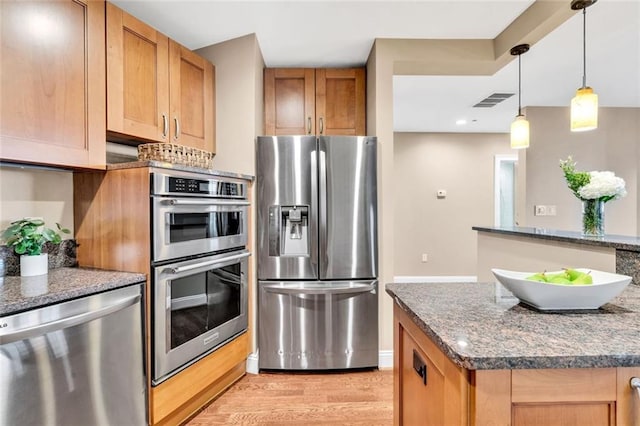 2881 Peachtree Rd NE Unit 1202, Atlanta, GA 30305 - kitchen featuring appliances with stainless steel finishes, light wood-type flooring, hanging light fixtures, dark stone countertops, and recessed lighting