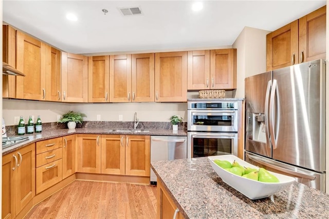 2881 Peachtree Rd NE Unit 1202, Atlanta, GA 30305 - kitchen featuring stainless steel appliances, a sink, light wood-style flooring, stone countertops, and recessed lighting