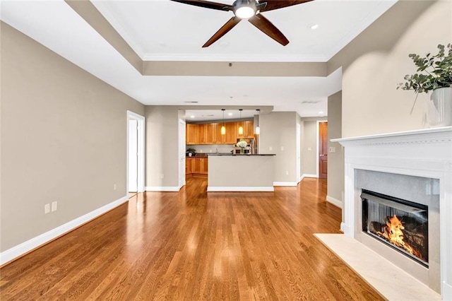 2881 Peachtree Rd NE Unit 1202, Atlanta, GA 30305 - unfurnished living room with wood finished floors, a ceiling fan, ornamental molding, a fireplace with flush hearth, and baseboards