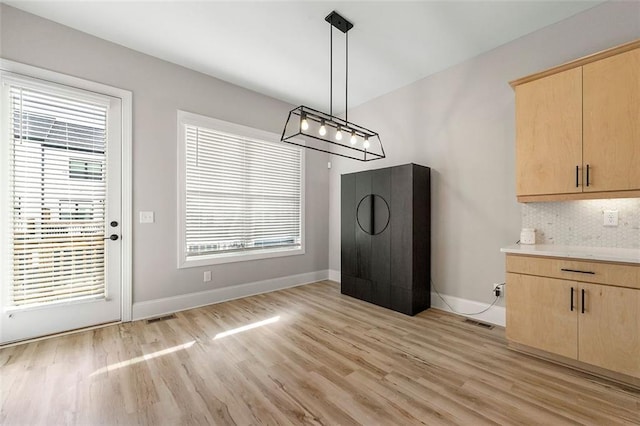 unfurnished dining area featuring plenty of natural light and light wood-type flooring