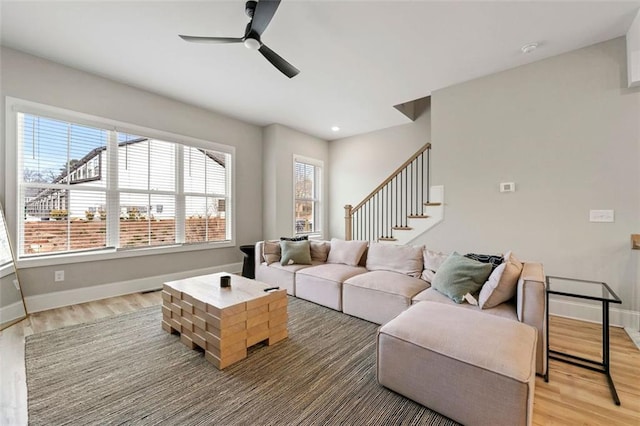 living room featuring wood-type flooring and ceiling fan