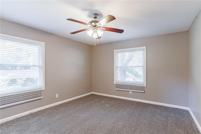 empty room with carpet floors, ceiling fan, and a healthy amount of sunlight