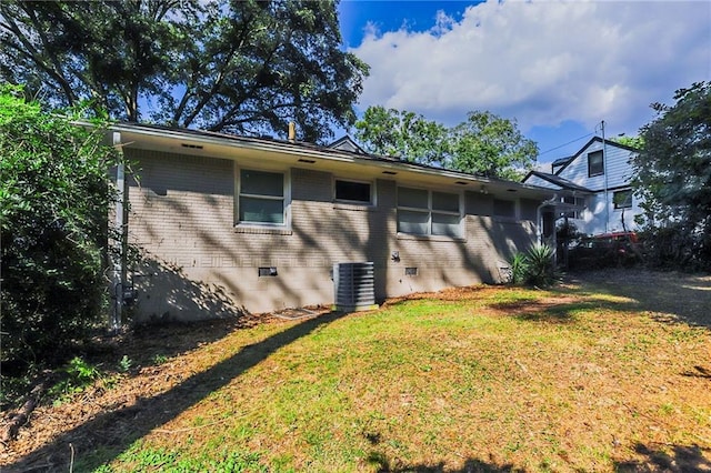 exterior space featuring central AC unit and a lawn