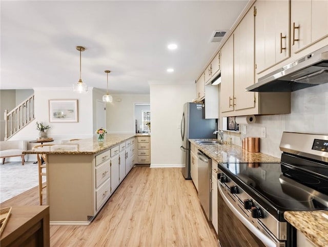2466 Thrasher Rd, Buford, GA 30519 - kitchen featuring appliances with stainless steel finishes, a peninsula, under cabinet range hood, light wood finished floors, and crown molding
