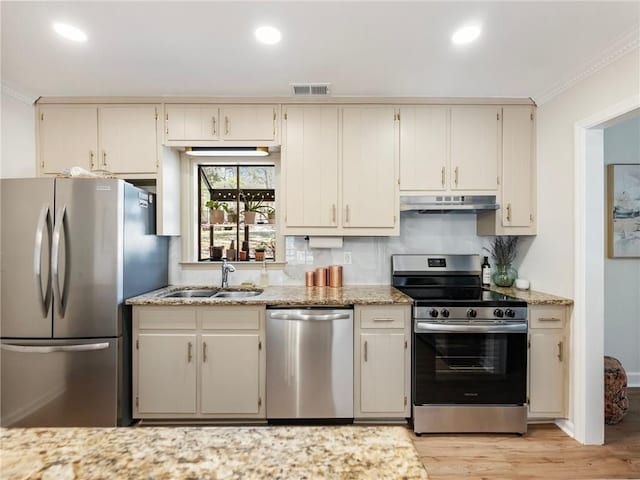 2466 Thrasher Rd, Buford, GA 30519 - kitchen with appliances with stainless steel finishes, a sink, under cabinet range hood, light wood finished floors, and light stone counters