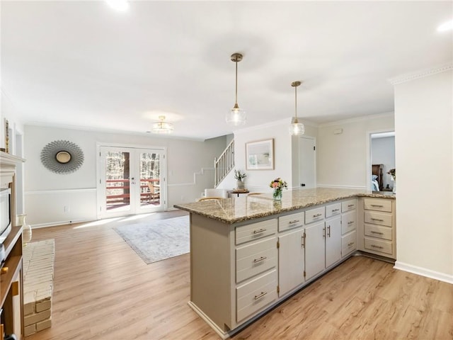 2466 Thrasher Rd, Buford, GA 30519 - kitchen with crown molding, light wood-style flooring, hanging light fixtures, french doors, and a peninsula