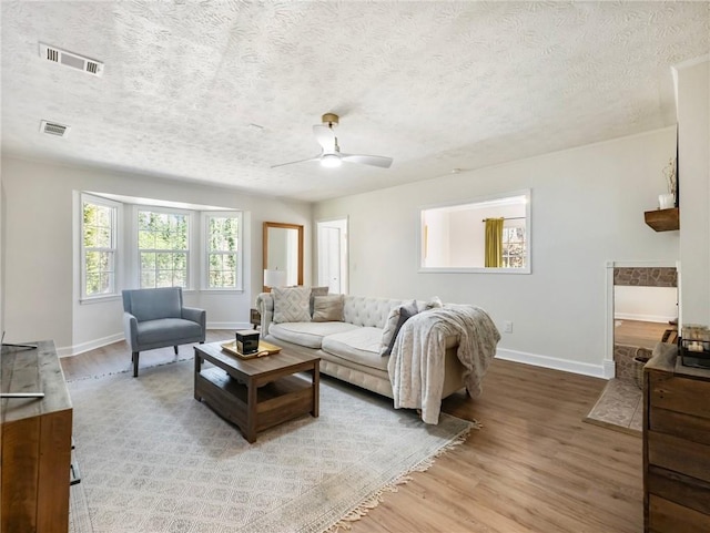 2466 Thrasher Rd, Buford, GA 30519 - living room featuring baseboards, a ceiling fan, light wood finished floors, and a textured ceiling
