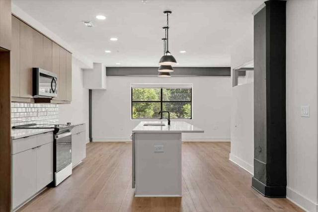 kitchen with stainless steel electric stove, light hardwood / wood-style floors, sink, and pendant lighting