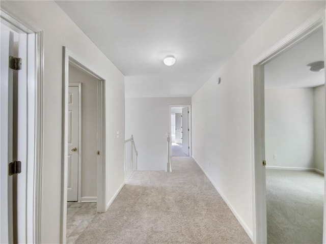 hallway featuring light colored carpet