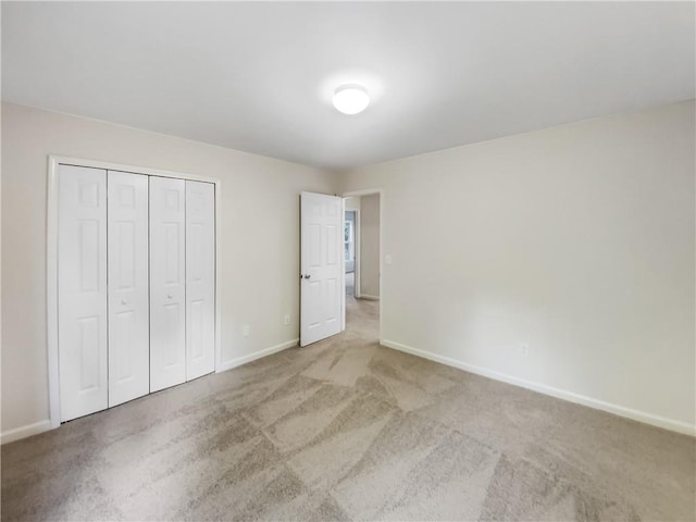 unfurnished bedroom with a closet and light carpet