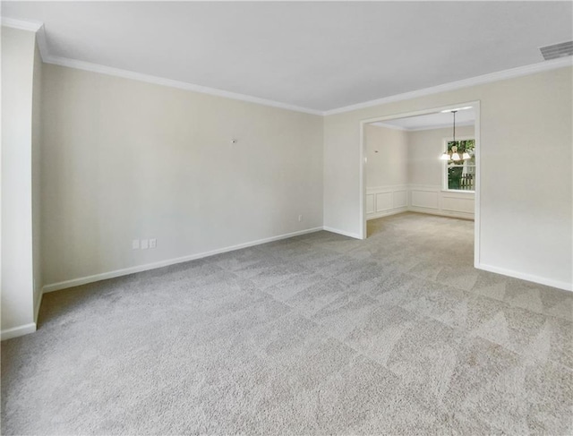 carpeted empty room with a notable chandelier and crown molding