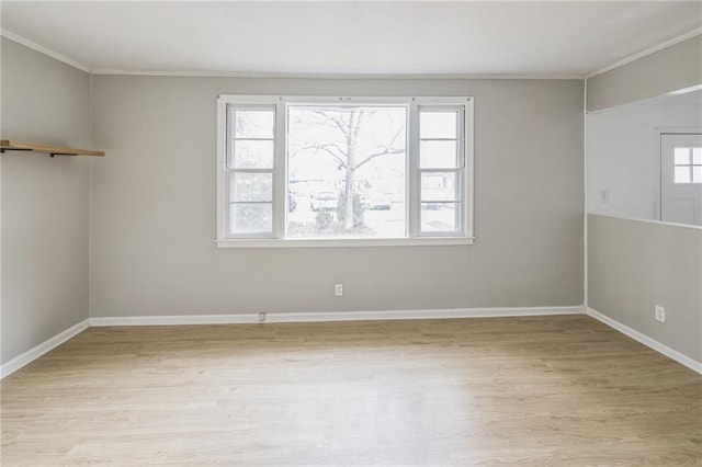 empty room with a wealth of natural light, light hardwood / wood-style flooring, and crown molding