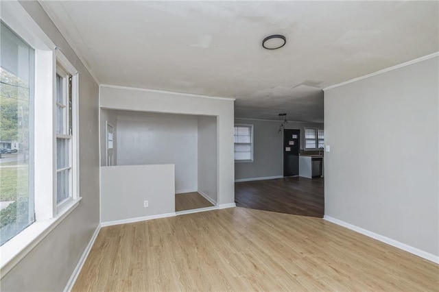 empty room featuring light wood-type flooring and ornamental molding