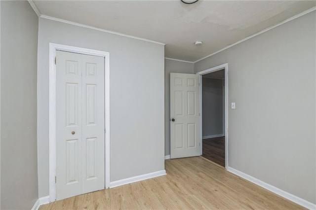 unfurnished bedroom featuring a closet, crown molding, and light hardwood / wood-style flooring