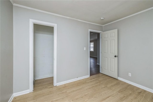 unfurnished bedroom with light hardwood / wood-style floors, ornamental molding, and a closet