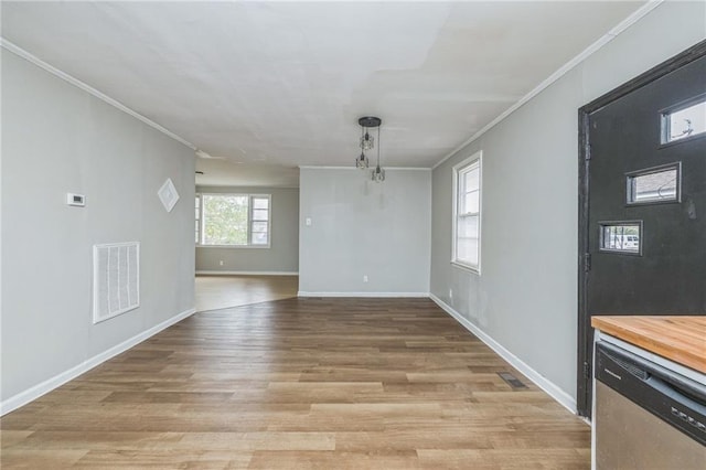 unfurnished dining area featuring crown molding and light hardwood / wood-style flooring