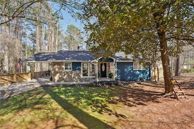 view of front facade with a carport, a front yard, and fence