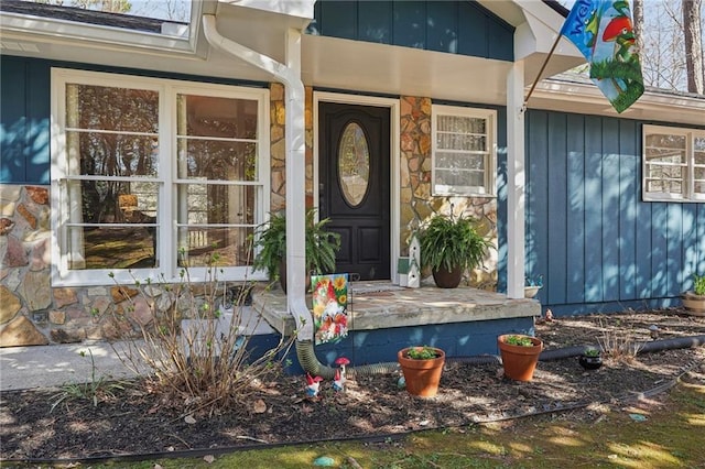 view of exterior entry with stone siding and board and batten siding