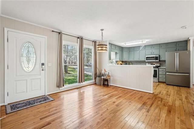 foyer entrance with crown molding and light wood-style flooring