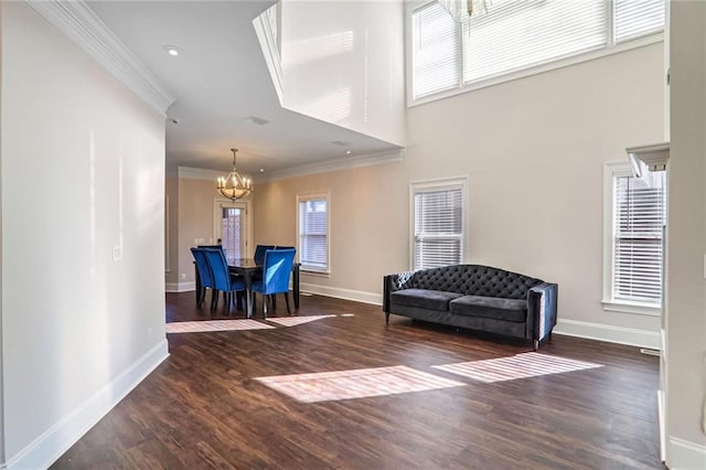 sitting room with ornamental molding, dark hardwood / wood-style floors, a wealth of natural light, and a notable chandelier