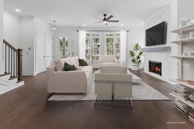 living area with stairs, wood finished floors, plenty of natural light, and a tile fireplace