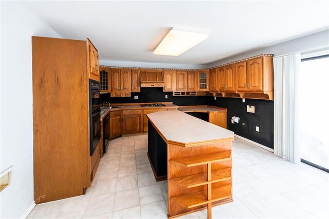 5479 Dorsett Shoals Rd, Douglasville, GA 30135 - kitchen with open shelves, brown cabinets, a center island, and glass insert cabinets