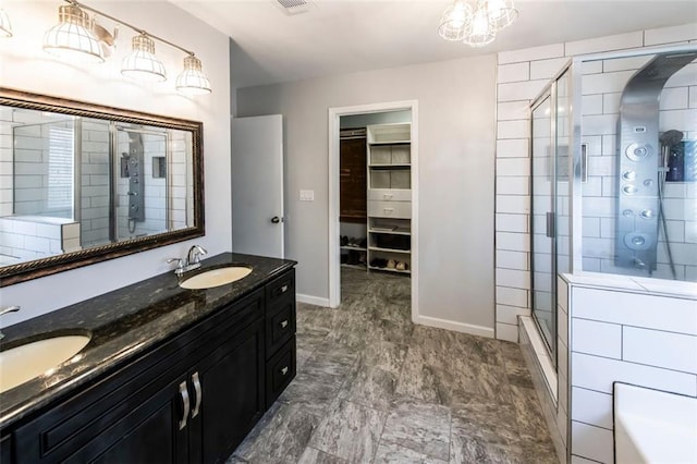 5479 Dorsett Shoals Rd, Douglasville, GA 30135 - bathroom with a shower stall, double vanity, a walk in closet, and baseboards