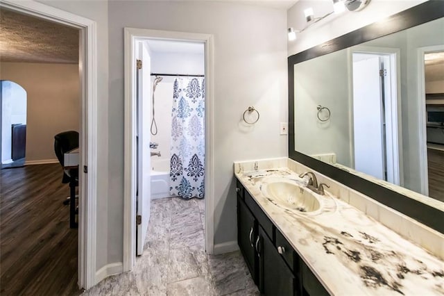 5479 Dorsett Shoals Rd, Douglasville, GA 30135 - bathroom with baseboards, vanity, shower / bath combo, and a textured ceiling