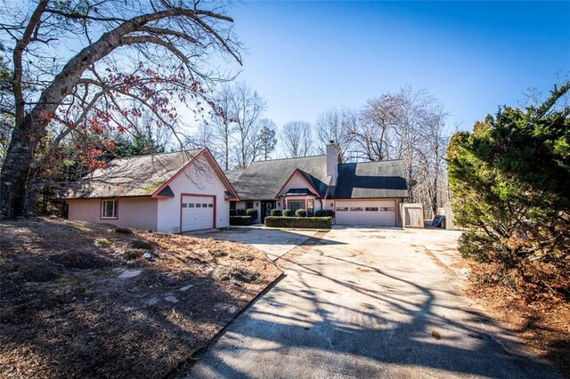 5479 Dorsett Shoals Rd, Douglasville, GA 30135 - view of front of home featuring concrete driveway, a chimney, a garage, and stucco siding