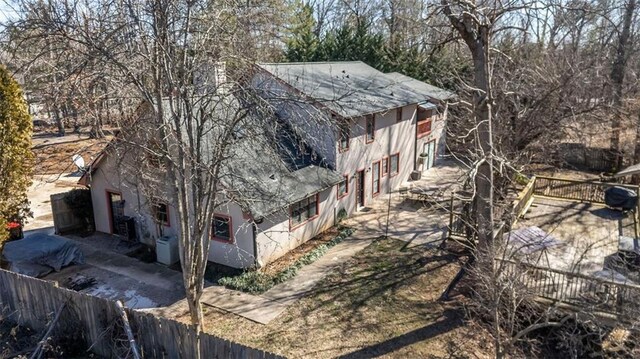 5479 Dorsett Shoals Rd, Douglasville, GA 30135 - view of side of property featuring roof with shingles, fence, stucco siding, and a patio area