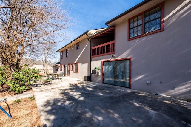 5479 Dorsett Shoals Rd, Douglasville, GA 30135 - back of house with stucco siding, a patio area, and a balcony