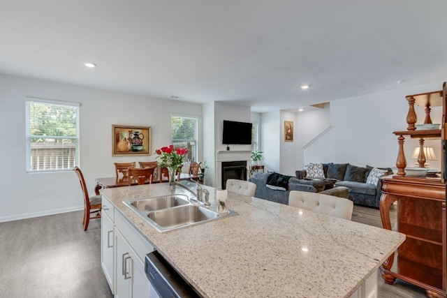 kitchen featuring white cabinets, light hardwood / wood-style floors, sink, and a healthy amount of sunlight