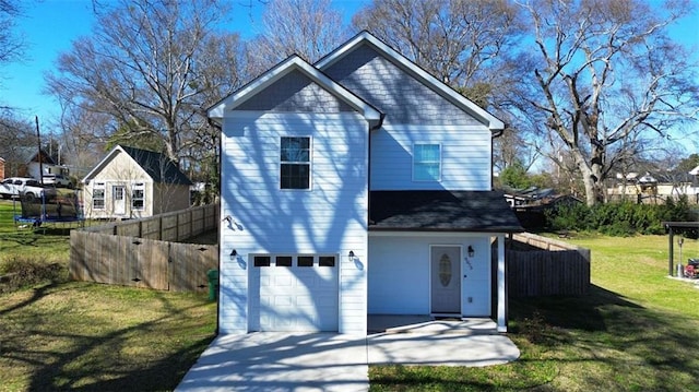 view of front of home with a garage, driveway, a front yard, and fence