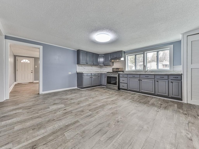 kitchen featuring gray cabinetry, sink, light hardwood / wood-style flooring, and gas stove