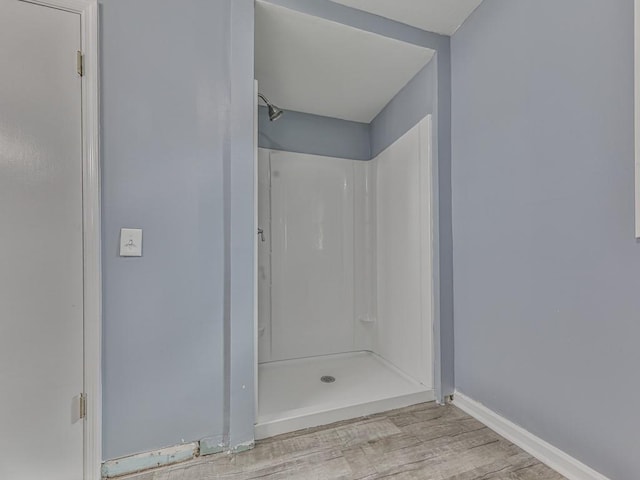 bathroom with walk in shower and hardwood / wood-style floors