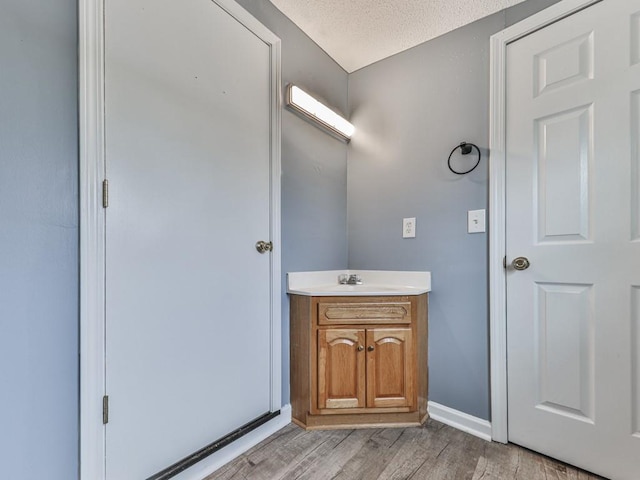 bathroom featuring vanity, hardwood / wood-style floors, and a textured ceiling