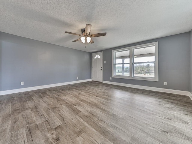 empty room with hardwood / wood-style flooring, a textured ceiling, and ceiling fan