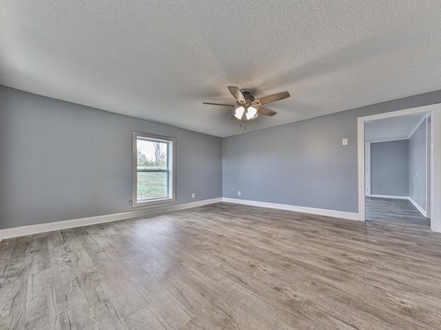 spare room with ceiling fan, a textured ceiling, and light hardwood / wood-style floors