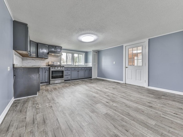 kitchen featuring tasteful backsplash, sink, gray cabinetry, stainless steel gas range, and light wood-type flooring